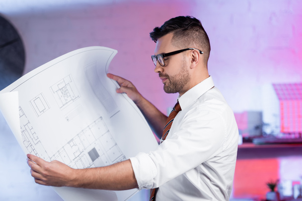 architect in eyeglasses looking at blueprint in architectural agency - Foto, Bild