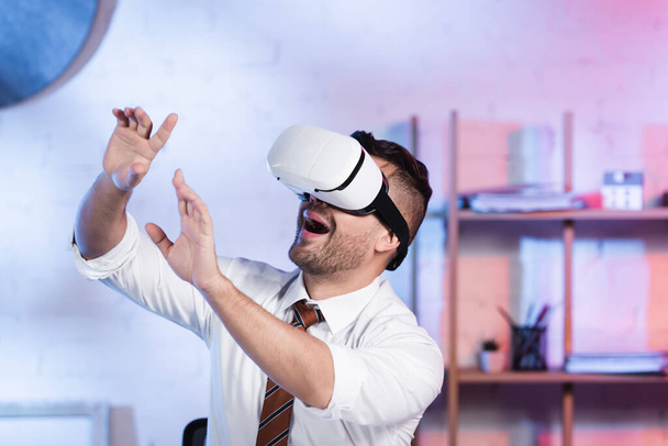 amazed architect gesturing while using vr headset in office - Foto, Imagen