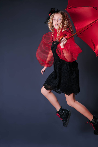 child girl jumping up with red umbrella - Foto, Bild
