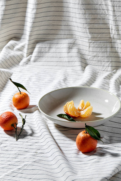 still life with mandarins on plate over drapery - Photo, image