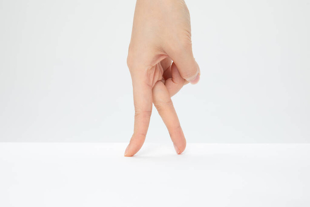 A closeup shot of a hand gesturing walking isolated on a white background - Fotografie, Obrázek