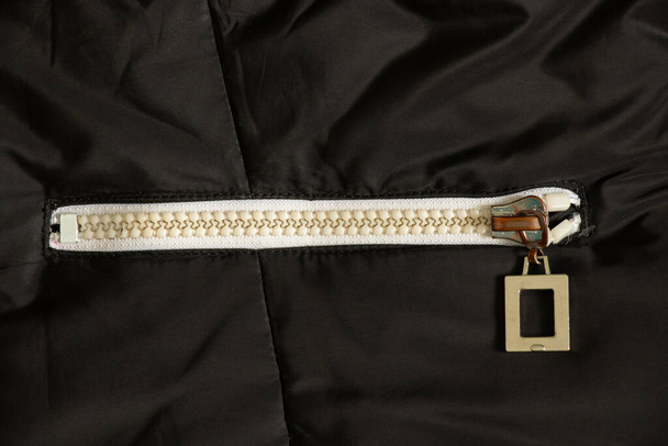 cremallera blanca sobre un fondo negro de cerca, cremallera sobre una chaqueta de cerca - Foto, imagen