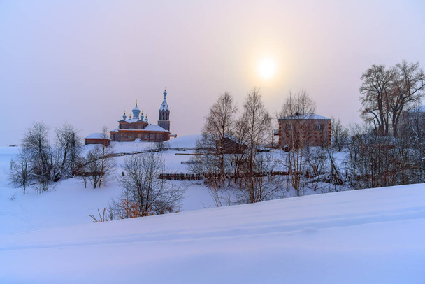 Zima w Cherdynie (północne Urale, Rosja) - miasto na 3 wzgórzach. gruba warstwa równego, czystego śniegu pokrywała góry, starożytne kościoły, budynki i drzewa. lekka mgła zstąpiła z mrozu - Zdjęcie, obraz