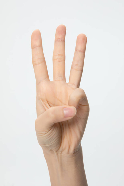 A vertical shot of a hand showing the number three isolated on a white background - 写真・画像