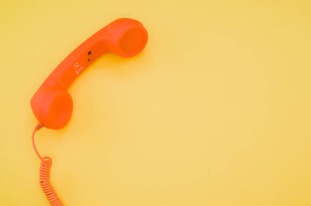 A classic orange handset on pastel yellow background for a copy space - Foto, Imagem