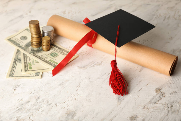 Diploma con cappello di laurea e denaro su sfondo chiaro - Foto, immagini