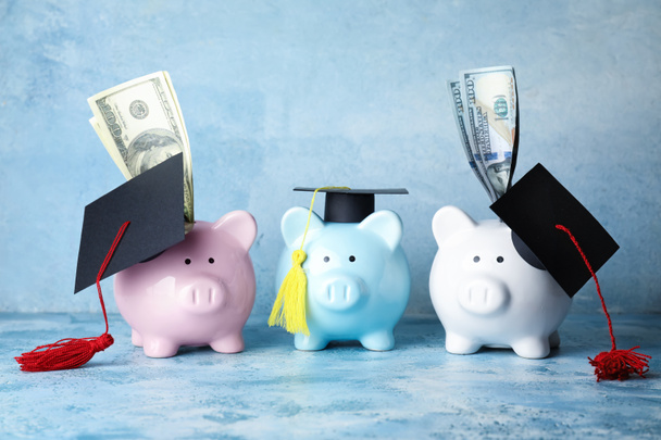 Hucha con sombreros de graduación y dinero sobre fondo de color - Foto, Imagen