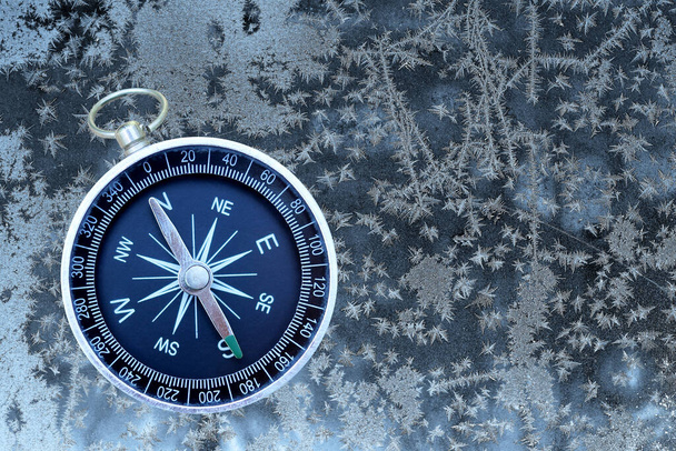 Klasszikus navigációs iránytű télen fagyasztott háttér szimbólumaként turizmus iránytű, utazás iránytű és szabadtéri tevékenységek iránytű - Fotó, kép