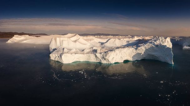 floating glaciers in the rays of the setting sun during a polar night - Photo, Image