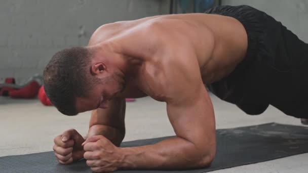 Starker Bodybuilder trainiert auf dem Boden im Sportraum - Filmmaterial, Video