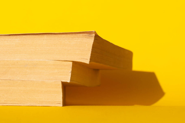 tres libros antiguos sobre un fondo amarillo. Leer libros - Foto, imagen