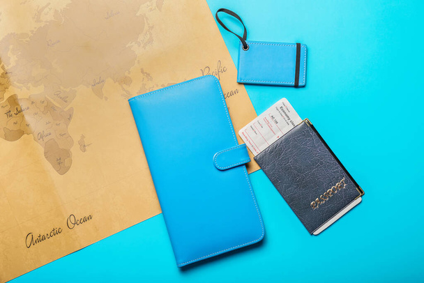 Οργανωτής ταξιδιού με διαβατήριο, εισιτήριο και παγκόσμιο χάρτη στο φόντο χρώμα - Φωτογραφία, εικόνα