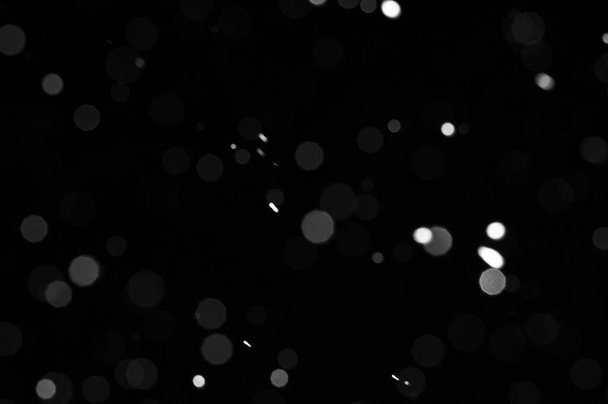 Bokeh di neve bianca su sfondo nero. Nevicata - nuovo elemento di design. - Foto, immagini