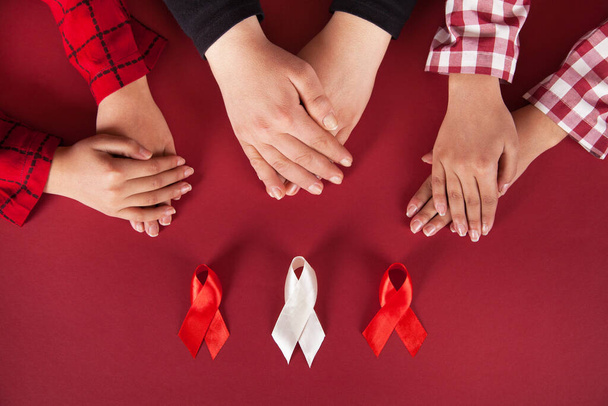 Ενηλίκων και παιδιών που κατέχουν κόκκινη κορδέλα, έννοια του Παγκόσμιου AIDS. - Φωτογραφία, εικόνα
