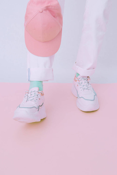 Details of trendy casual spring summer outfit. Girl in studio wearing white jeans and stylish  sneakers. Everyday look. Street fashion concept. No face. Minimalist  pastel colours aesthetic. - Valokuva, kuva
