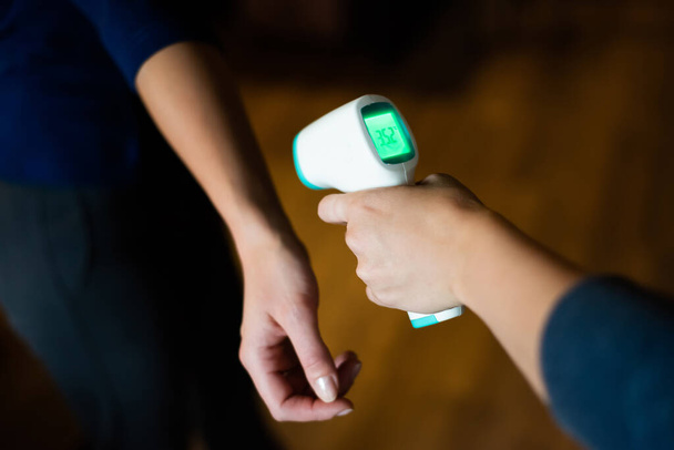Body temperature measurement with infrared wrist thermometer. - Zdjęcie, obraz