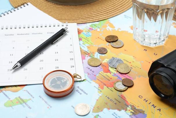 Different travel accessories on world map. Planning summer vacation trip - Valokuva, kuva