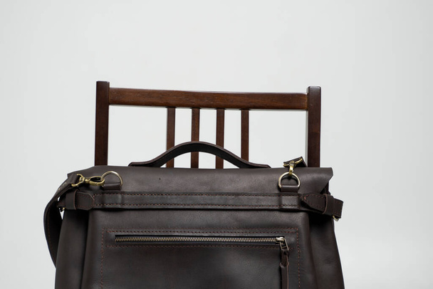 Brown mens shoulder leather bag for a documents and laptop on a brown chair with a white background. Mens leather brief case, messenger bags, leather satchel, handmade briefcase. - Foto, Imagem