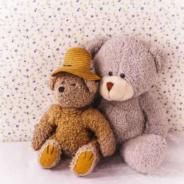 Two old teddy bears are sitting nearby. Support, love, tender relationship and age. - Photo, Image