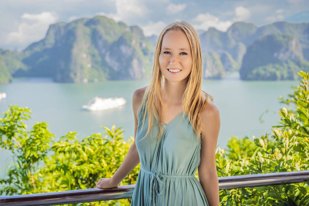 Attractive woman in a dress is traveling in Halong Bay. Vietnam. Travel to Asia, happiness emotion, summer holiday concept. Picturesque sea landscape. Ha Long Bay, Vietnam - Zdjęcie, obraz