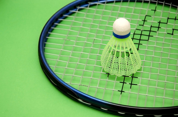 Shuttlecock and racket on green background - Photo, Image
