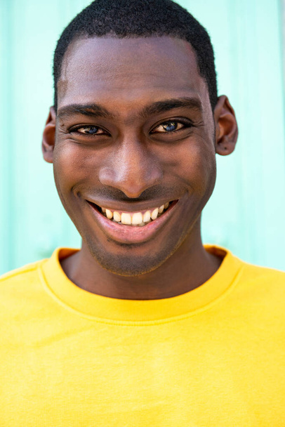 Крупным планом портрет улыбается красивый молодой черный мужчина - Фото, изображение