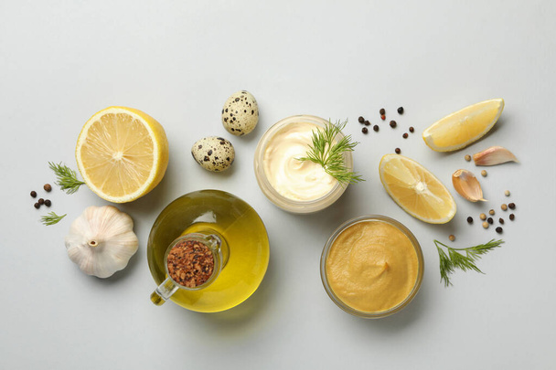 Чаша с майонезом и ингредиентами для приготовления пищи на белом фоне, вид сверху - Фото, изображение