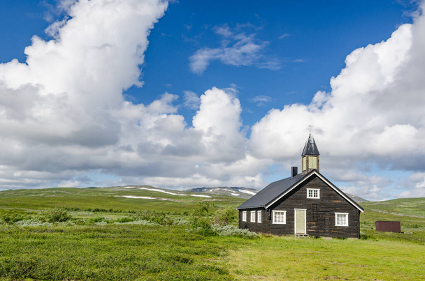 Kleine zwarte houten kerk op groene heuvels Noorse toendra Hammerfest - Foto, afbeelding