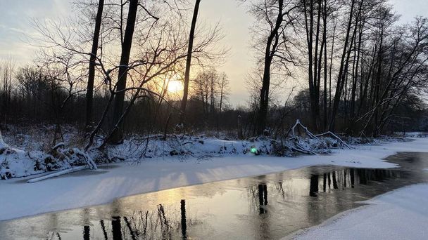 Zimowy krajobraz rzeka  zamarznita pola i lasy w okolicach Wlodawy pokrytej duo niegu niego w zlotejj godzinie - Foto, Bild