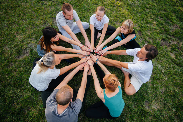 A group of people do yoga in a circle in the open air during sunset. Healthy lifestyle, meditation and Wellness - Foto, Bild