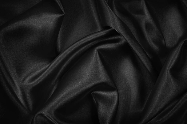 Black silk satin texture background. Beautiful wavy soft folds on shiny smooth fabric. Anniversary, event, card, invitation, concept. Black elegant background with copy space for design.                                - Fotoğraf, Görsel