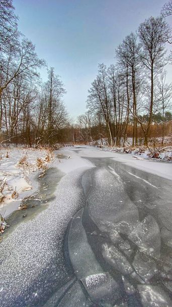 Zimowy krajobraz rzeka cucowo zamarznita pola i lasy w okolicach Wodawy pokrytej duo niego w zotej godzinie - 写真・画像