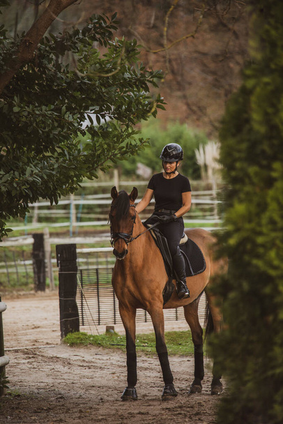 Всадник верхом на лошади на своем ранчо по пути к конюшне - Фото, изображение
