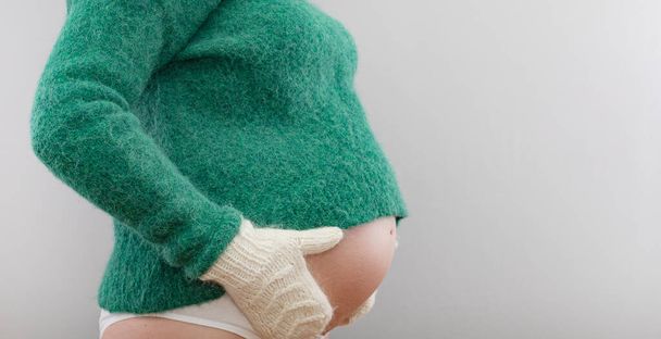 Těhotná žena ve vlněném svetru a teplých rukavicích - Fotografie, Obrázek