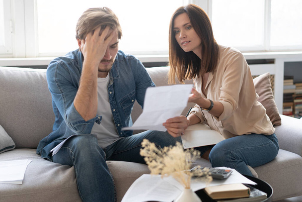 Photo of cheerful young couple analyzing their finances with documents - Foto, immagini