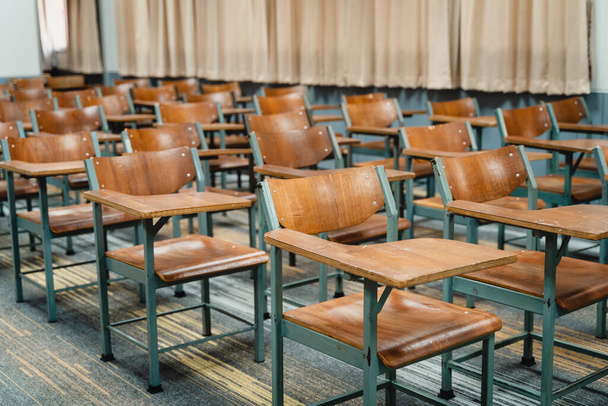 Drewniane krzesła wykładowe rozmieszczone w klasie. Pusta klasa koledżu z wieloma drewnianymi krzesłami wykładowymi, ale bez studentów. Powrót do koncepcji szkoły. - Zdjęcie, obraz