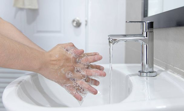 Os homens estão lavando as mãos nas pias para limpar bactérias respiratórias e vírus, saneamento e reduzir a propagação de COVID-19 que está espalhado ao redor do mundo, Higiene, conceito de saneamento. - Foto, Imagem