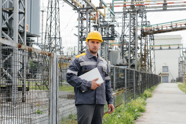 The energy engineer inspects the equipment of the substation. Power engineering. Industry - Valokuva, kuva