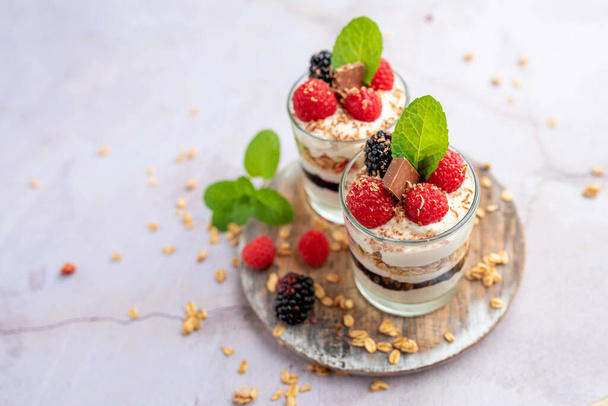 Greek yogurt raspberry parfaits in glass jars, small healthy dessert - Фото, изображение