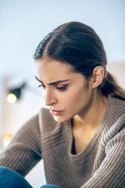 Dark-haired young woman looking stressed and unhappy - Photo, image