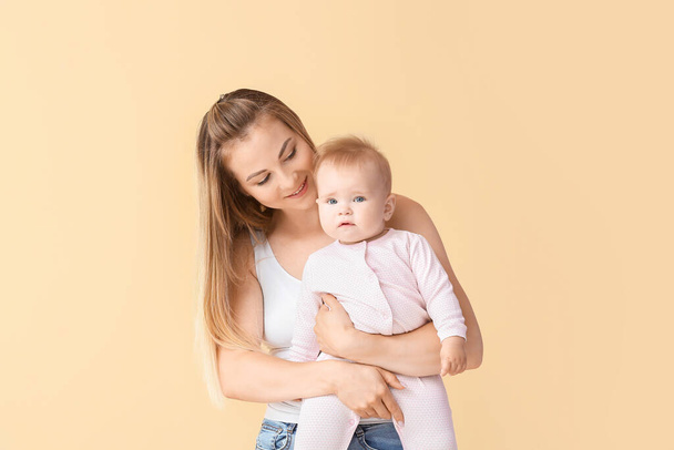 Mère heureuse avec mignon petit bébé sur fond de couleur - Photo, image