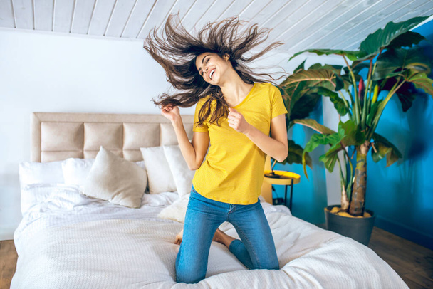 Long-haired beautiful young woman looking cheerful and excited - 写真・画像