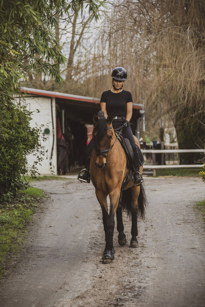 Reiter reitet mit seinem Pferd auf seiner Ranch auf dem Weg zum Stall - Foto, Bild