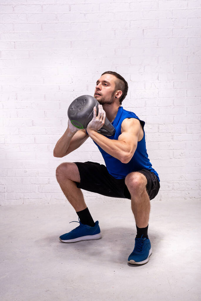 Fitness with a kettlebell, a man trains with a kettlebell. Active lifestyle, sports. - Foto, Bild