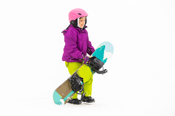 Pieni söpö tyttö lumilautailu hiihtokeskuksessa aurinkoisena talvipäivänä. - Valokuva, kuva