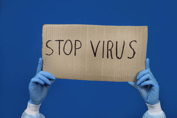 Hände eines Arztes oder einer Krankenschwester mit einem Plakat gegen das Virus - Foto, Bild