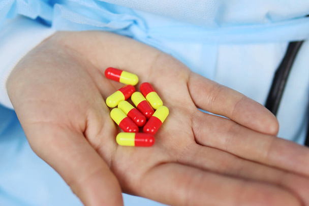 Cápsulas coloreadas comprimidos en la mano de un médico o enfermero - Foto, Imagen