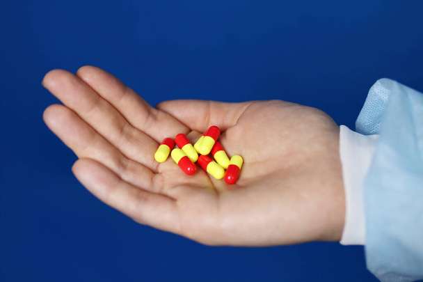 Capsules colorées comprimés dans la main d'un médecin ou d'une infirmière - Photo, image