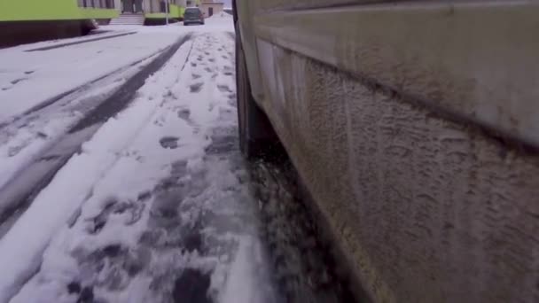 Gros plan de la roue d'une voiture sur une route en condition hivernale - Séquence, vidéo