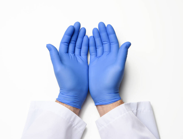 dos manos masculinas en guantes de látex azul, las palmas del médico sobre un fondo blanco, vista superior - Foto, Imagen